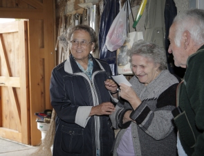 Dora Wiesli-Braun mit Herrn und Frau Ehrbar auf dem Hof im Freudenberg 99. Dort erfreut man sich an alten Fotos.